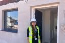 Somerset Council project officer Alex Williams outside one of the new council houses on Rainbow Way in Minehead.