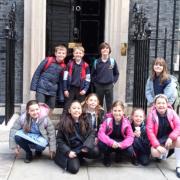 Children from St Mary's Catholic Primary School outside the front door of number 10.