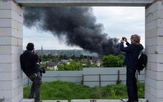 Foreign journalists report from an observation point while smoke rises after a Russian attack in Kharkiv, Ukraine (AP Photo/Evgeniy Maloletka)
