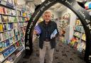 Derek Sturch, new Devon-based author standing in Archway Bookshop in Axminster holding his two books.