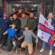 Liberty Trail walkers greeted at Lyme Regis lifeboat station by volunteer crew members Gareth Roscoe and Petrina Muscroft.