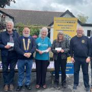 Lions members donating funds to members of the community hub building, Hospiscare and Honiton Museum