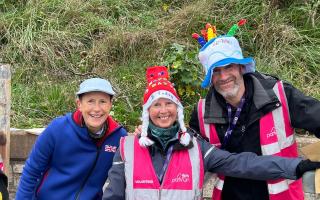 Marilyn Hughes (centre) receives a prize from Event Directors, Carol Austin and Tony Smith for volunteering the most times over the eight years of Seaton parkrun