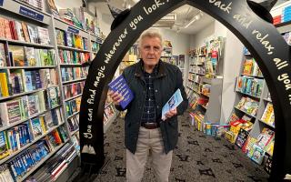 Derek Sturch, new Devon-based author standing in Archway Bookshop in Axminster holding his two books.